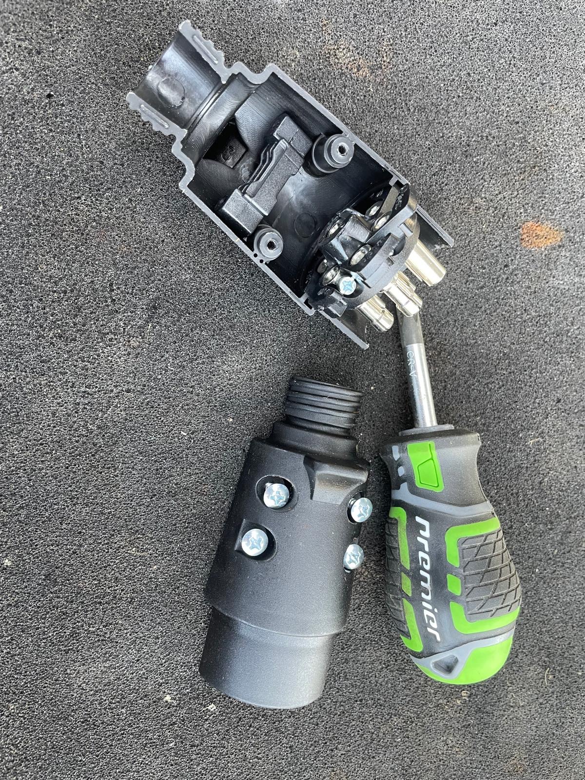 Opening a 7 pin 12N trailer plug with a screwdriver to access the pin terminals
